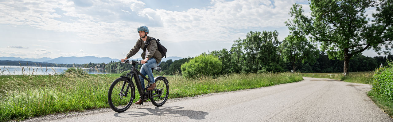 Ein Mann fährt mit seinem Riese und Müller e-Bike durch die Natur